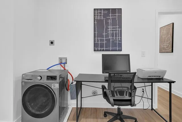 a view of a workspace with furniture and a window