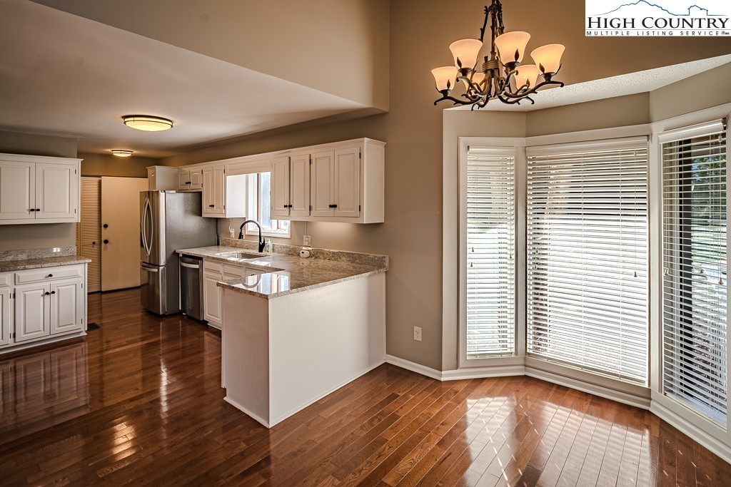 290 Cobble Creek Lane Boone, NC 28607 - Photo 11 of 33 a kitchen with stainless steel appliances granite countertop a refrigerator a sink dishwasher a stove and white cabinets with wooden floor