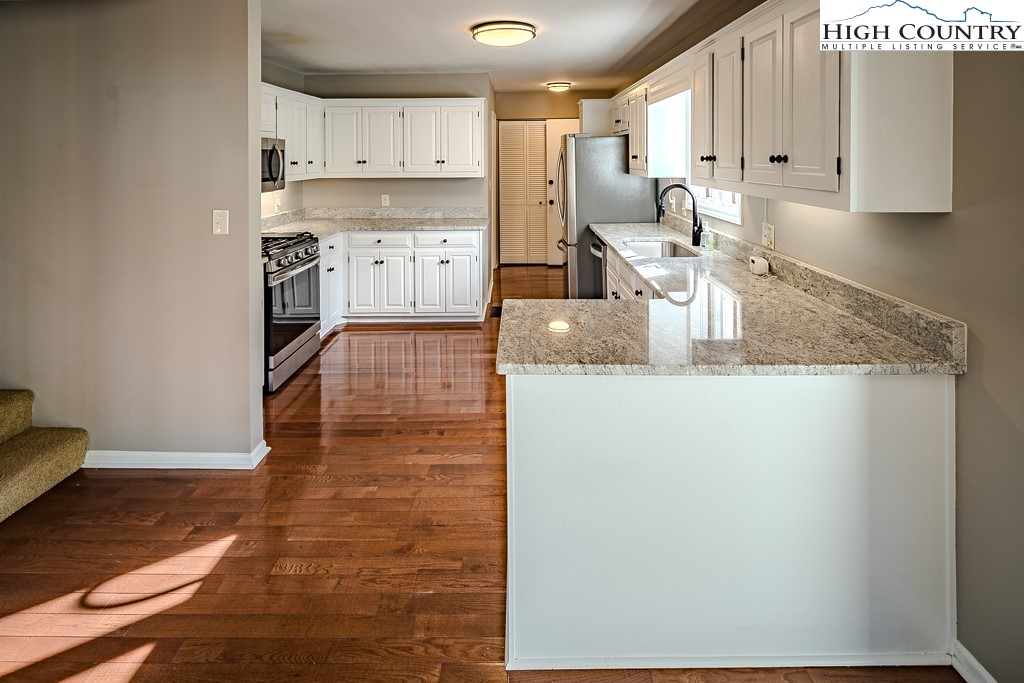290 Cobble Creek Lane Boone, NC 28607 - Photo 12 of 33 a kitchen with stainless steel appliances granite countertop a sink stove and cabinets