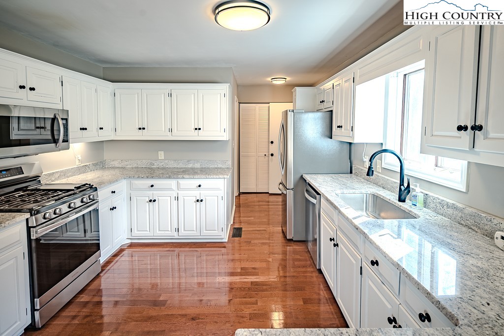 290 Cobble Creek Lane Boone, NC 28607 - Photo 13 of 33 a kitchen with granite countertop a stove a sink and a refrigerator