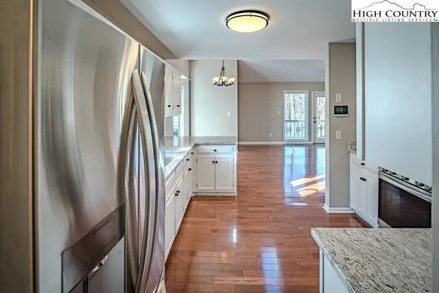 a spacious bedroom with a bed painting on wall and a large window