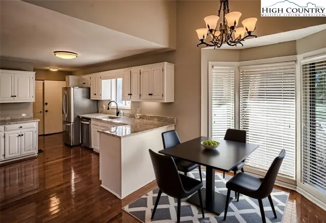 a kitchen with a dining table chairs and refrigerator