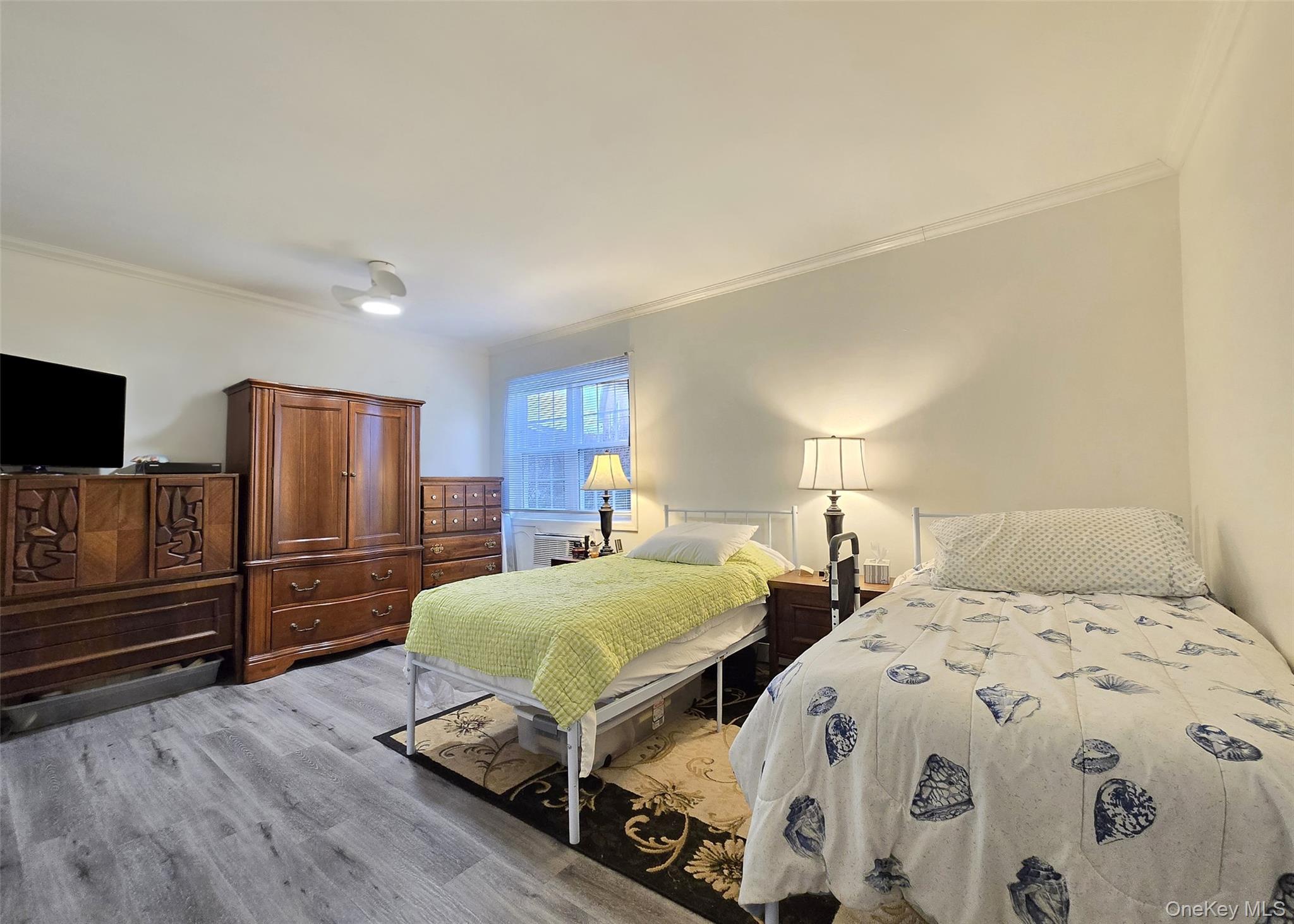 460 Old Town Road, Unit 5B East Setauket, NY 11772 - Photo 8 of 12 a bedroom with two beds and a flat screen tv