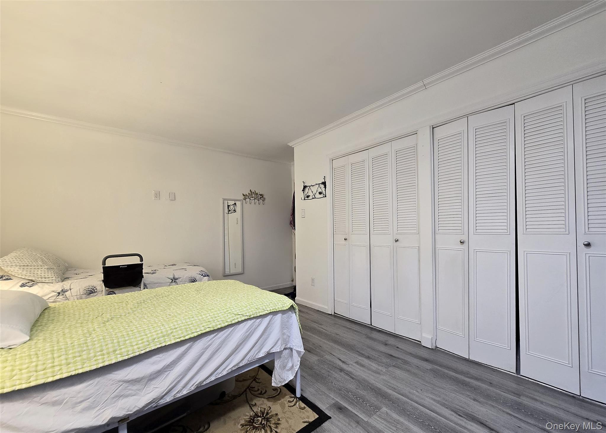 460 Old Town Road, Unit 5B East Setauket, NY 11772 - Photo 9 of 12 a bedroom with a bed and wooden floor