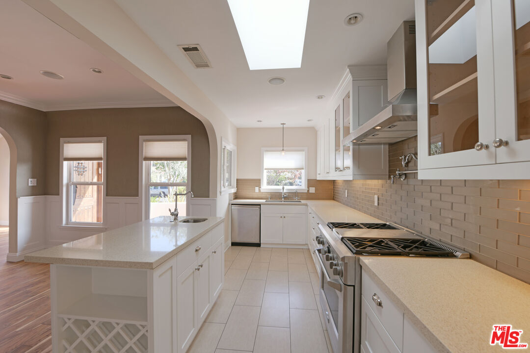 1657 South Point View Street Los Angeles, CA 90035 - Photo 11 of 50 a kitchen with a stove a sink and a refrigerator