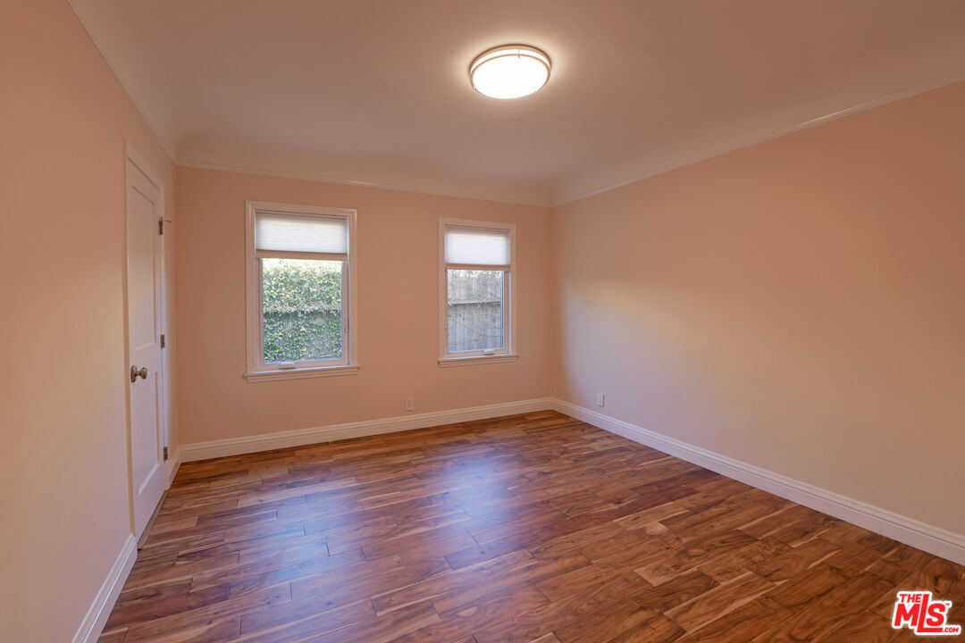 1657 South Point View Street Los Angeles, CA 90035 - Photo 15 of 50 an empty room with wooden floor and windows