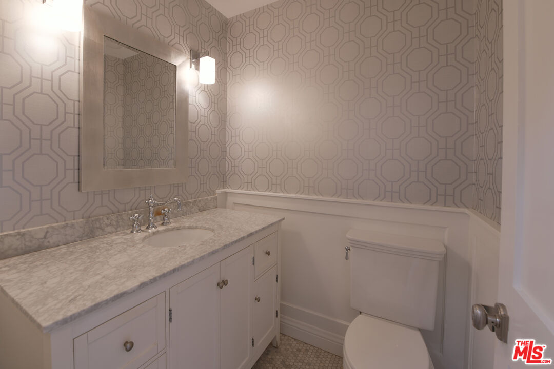1657 South Point View Street Los Angeles, CA 90035 - Photo 16 of 50 a bathroom with a granite countertop sink vanity mirror and toilet