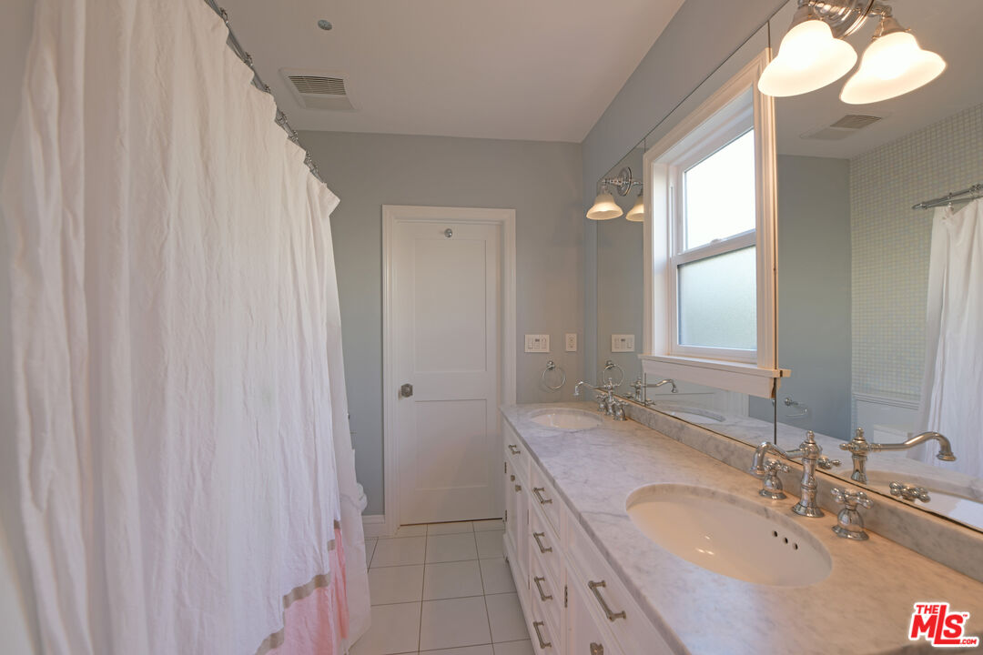 1657 South Point View Street Los Angeles, CA 90035 - Photo 18 of 50 a bathroom with a granite countertop sink and a mirror
