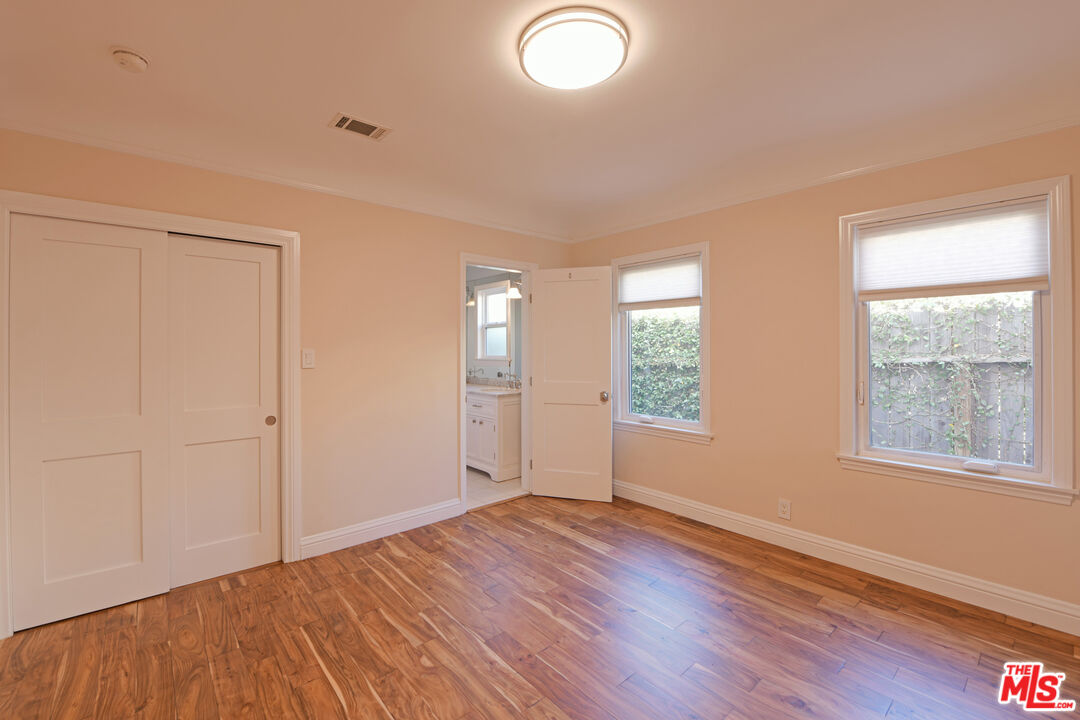 1657 South Point View Street Los Angeles, CA 90035 - Photo 19 of 50 an empty room with wooden floor and windows
