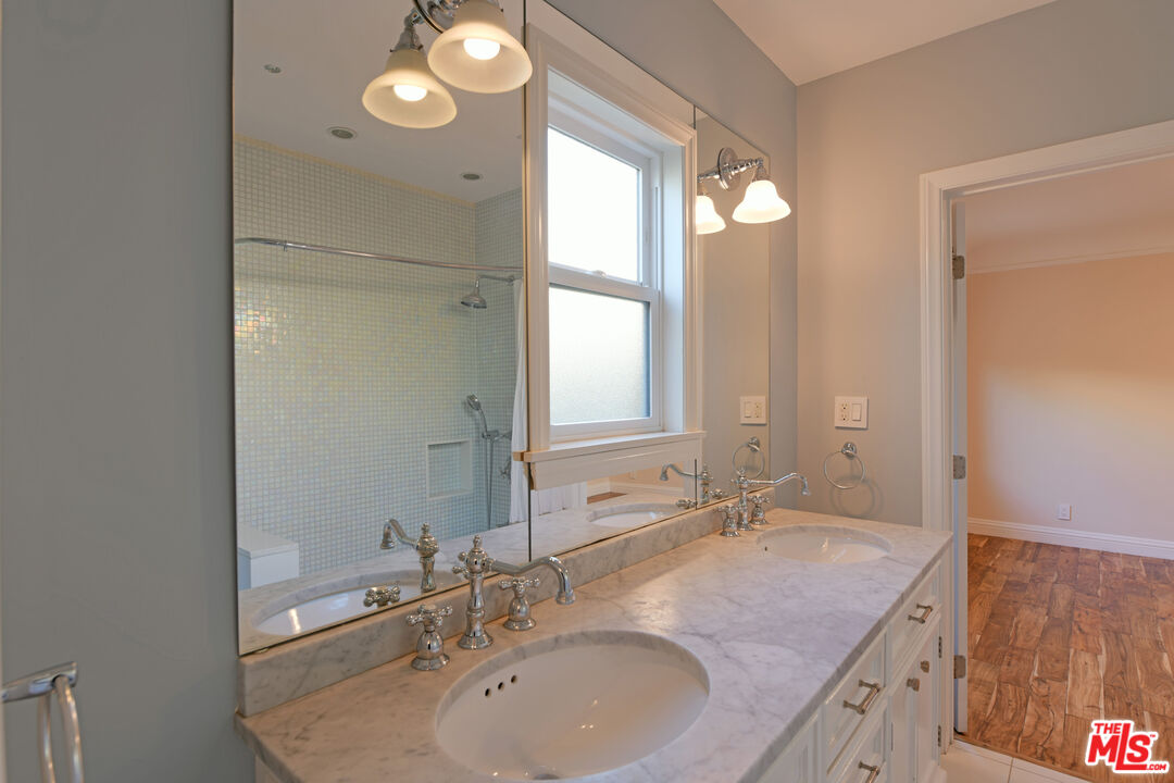1657 South Point View Street Los Angeles, CA 90035 - Photo 22 of 50 a bathroom with a granite countertop sink and a mirror