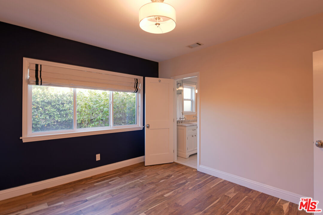 1657 South Point View Street Los Angeles, CA 90035 - Photo 23 of 50 an empty room with wooden floor and windows