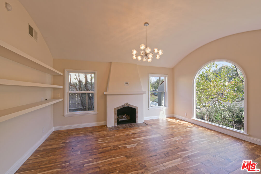 1657 South Point View Street Los Angeles, CA 90035 - Photo 33 of 50 a view of a livingroom with a fireplace wooden floor and chandelier