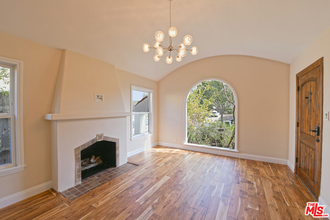 1657 South Point View Street Los Angeles, CA 90035 - Photo 34 of 50 a view of a livingroom with a fireplace wooden floor and chandelier