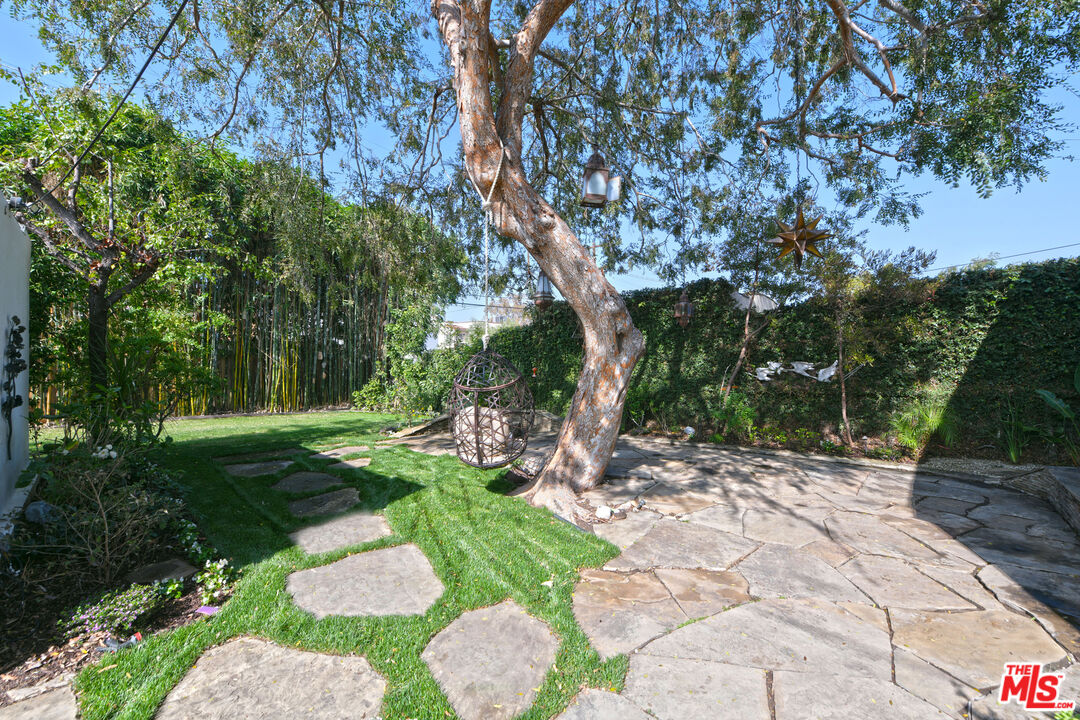 1657 South Point View Street Los Angeles, CA 90035 - Photo 41 of 50 a view of backyard with table and chairs and a large tree
