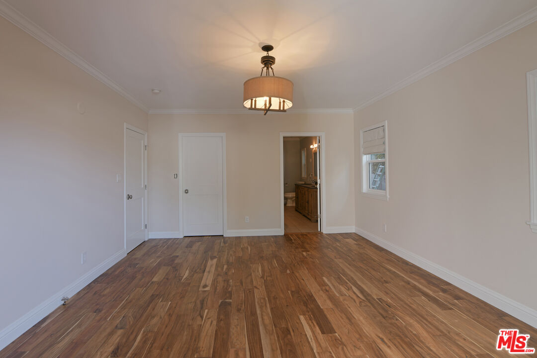 1657 South Point View Street Los Angeles, CA 90035 - Photo 7 of 50 a view of an empty room with wooden floor and a window