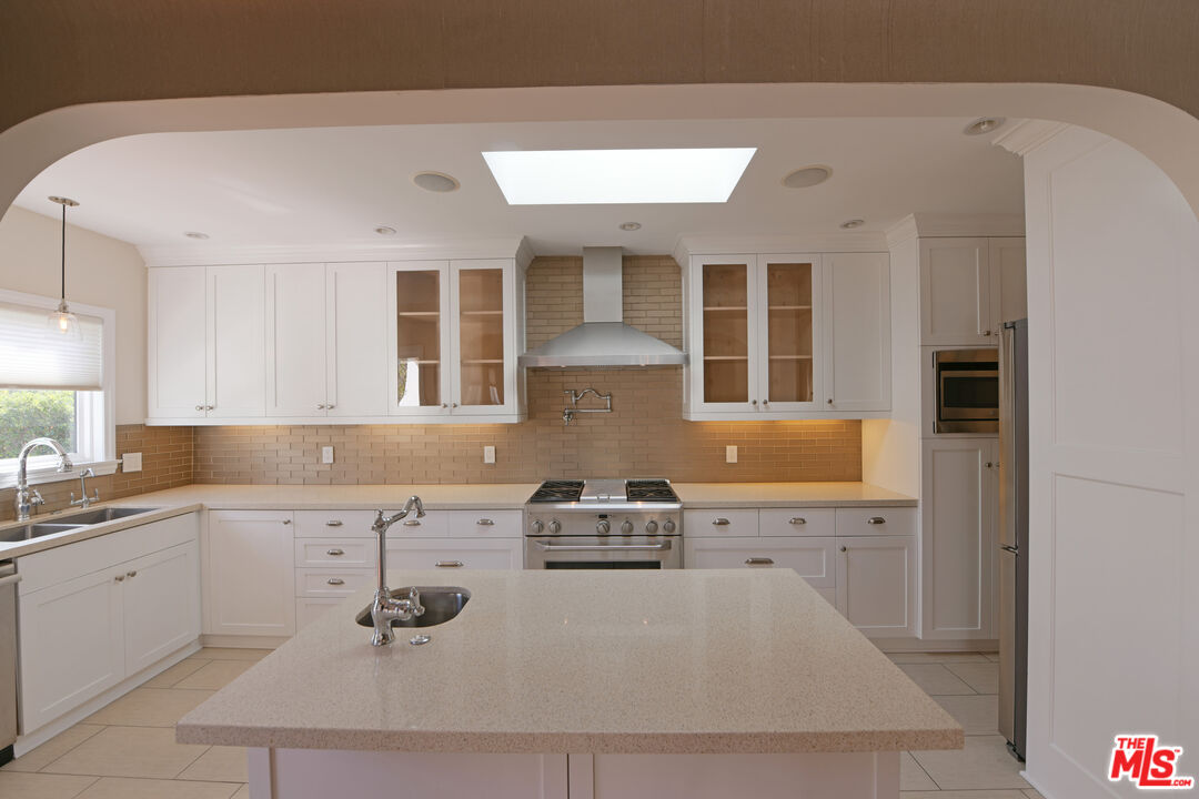 1657 South Point View Street Los Angeles, CA 90035 - Photo 8 of 50 a kitchen with sink refrigerator and cabinets