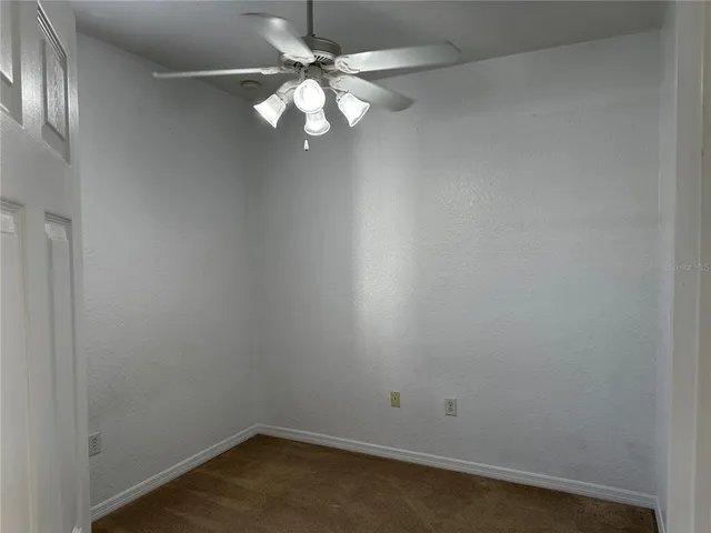 an empty room with a chandelier fan