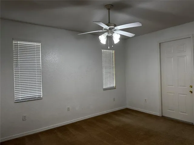 an empty room with a window and a fan