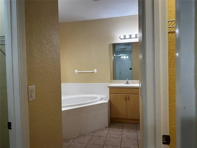 a bathroom with a tub sink and mirror