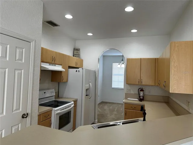 a kitchen with stainless steel appliances granite countertop a sink a stove and a refrigerator