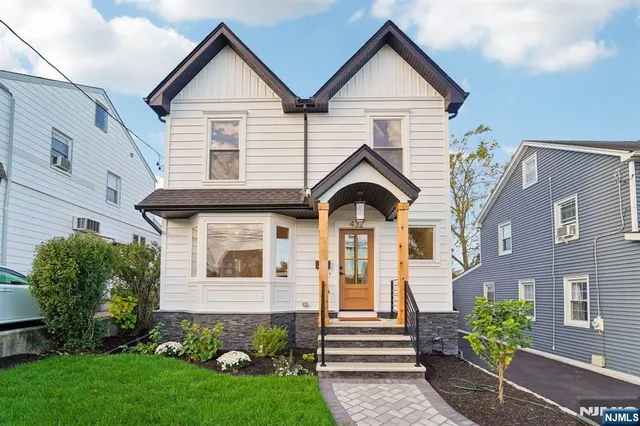 a view of a white house next to a yard