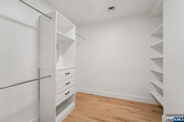 a view of walk in closet with empty racks