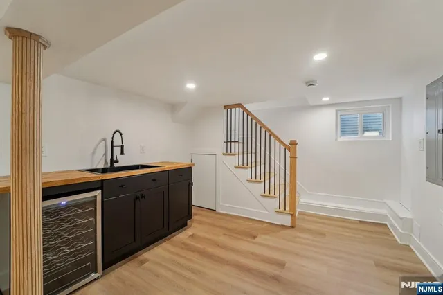 a hallway with wooden cabinets and sink