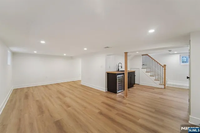 a view of an empty room with wooden floor and windows
