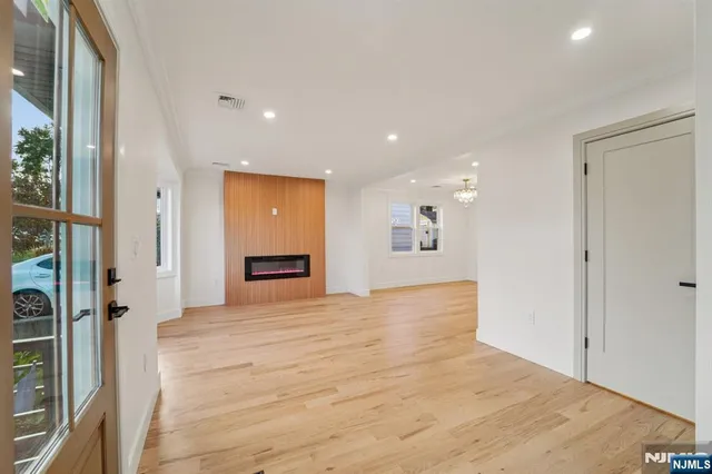 a view of a hallway with wooden floor and a bathroom