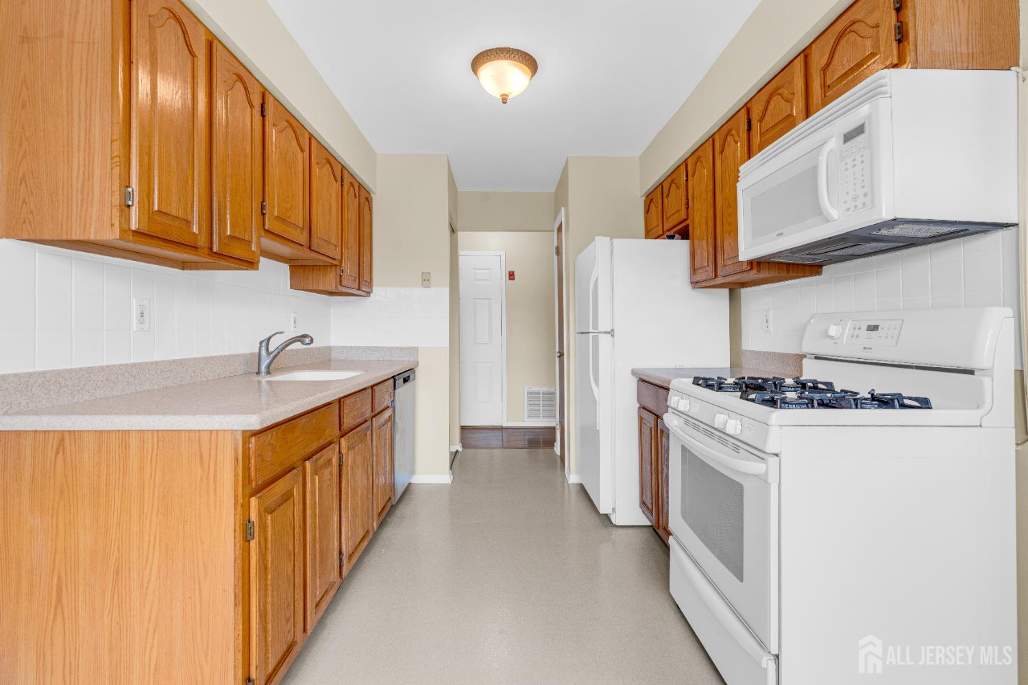101 Beverly Hl Terrace, Unit M Woodbridge, NJ 07095 - Photo 11 of 28 a kitchen with stainless steel appliances granite countertop a stove and a refrigerator
