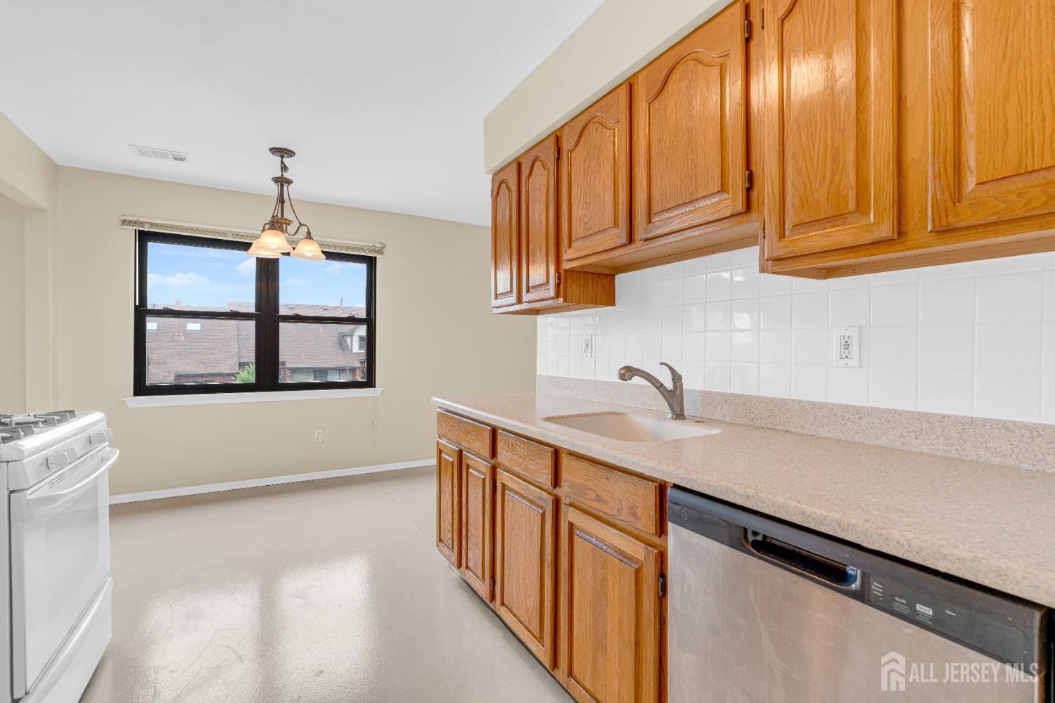 101 Beverly Hl Terrace, Unit M Woodbridge, NJ 07095 - Photo 13 of 28 a kitchen with stainless steel appliances granite countertop a sink a stove and a wooden cabinets