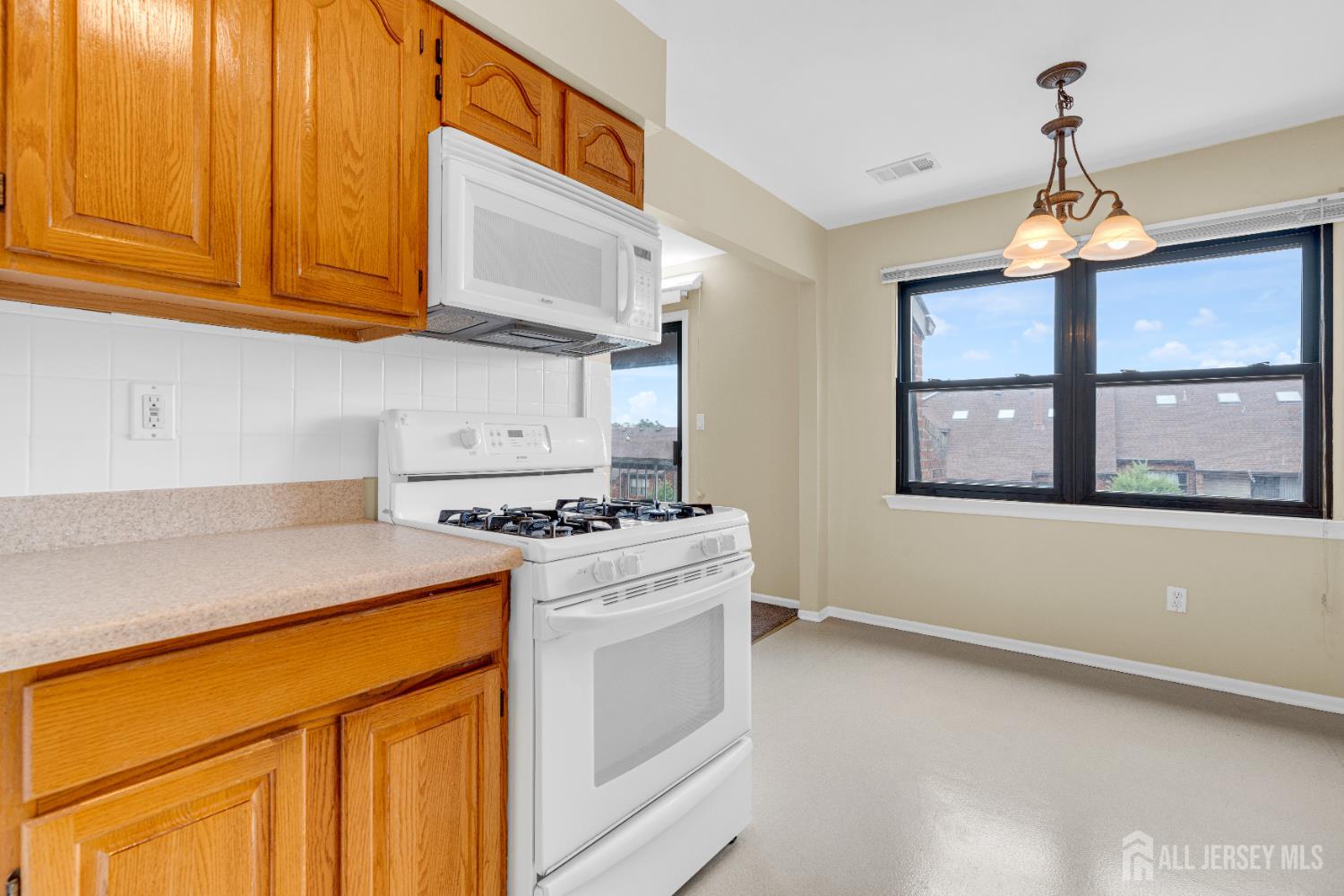 101 Beverly Hl Terrace, Unit M Woodbridge, NJ 07095 - Photo 14 of 28 a kitchen that has a stove and a white wooden cabinets
