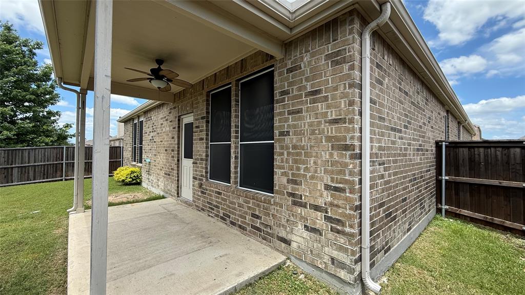 2213 Heaton Street Forney, TX 75126 - Photo 13 of 14 Covered patio with a ceiling fan, brick exterior, and a fenced yard
