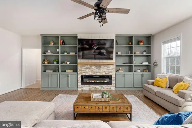 a living room with furniture fireplace and wooden floor