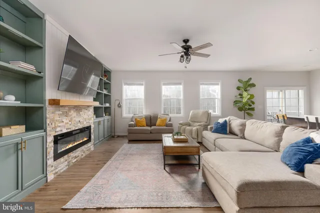 a living room with furniture white walls and kitchen view