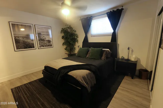 a bedroom with a bed and wooden floor