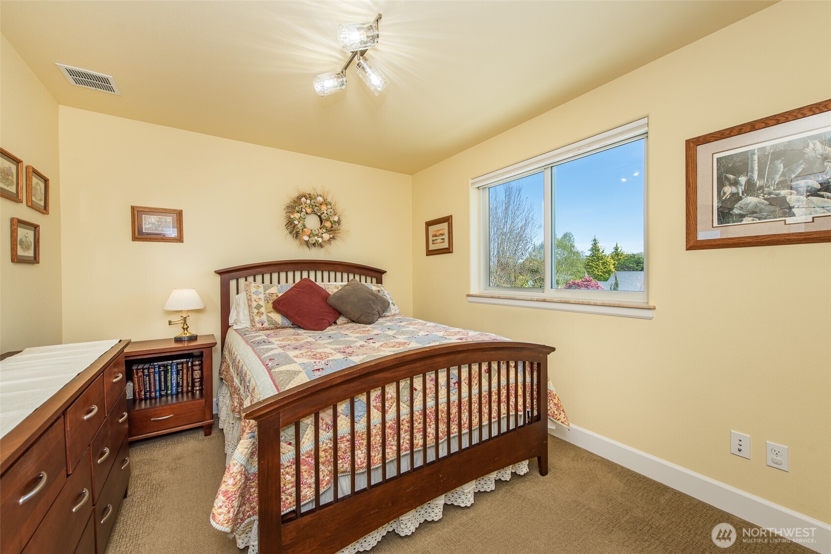 141 Pheasant Run Drive Sequim, WA 98382 - Photo 22 of 40 a bedroom with a bed and a chandelier