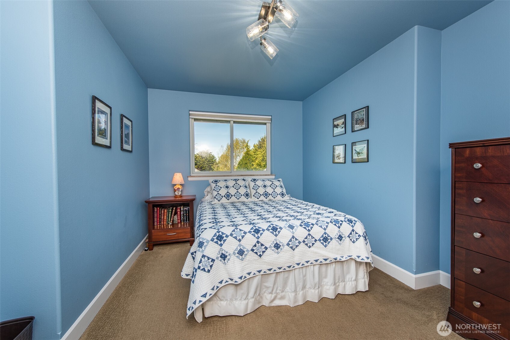 141 Pheasant Run Drive Sequim, WA 98382 - Photo 26 of 40 a bedroom with a bed and a chandelier