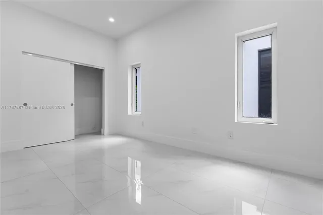 an empty room with windows and closet