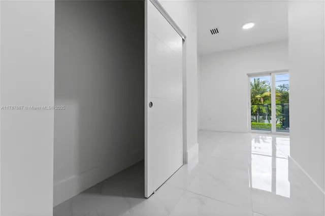 an empty room with windows and plants