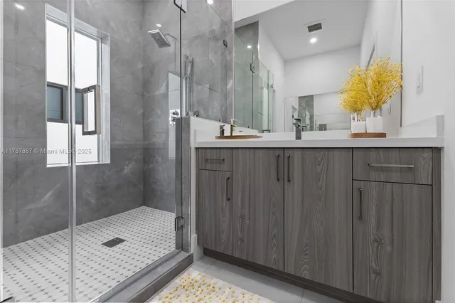 a bathroom with a double vanity sink mirror and shower