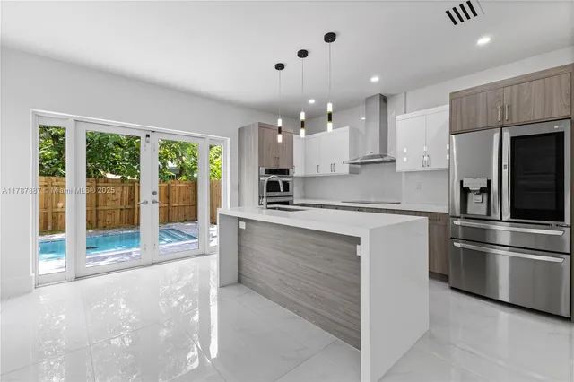 a kitchen with kitchen island a counter top space stainless steel appliances and a counter top space