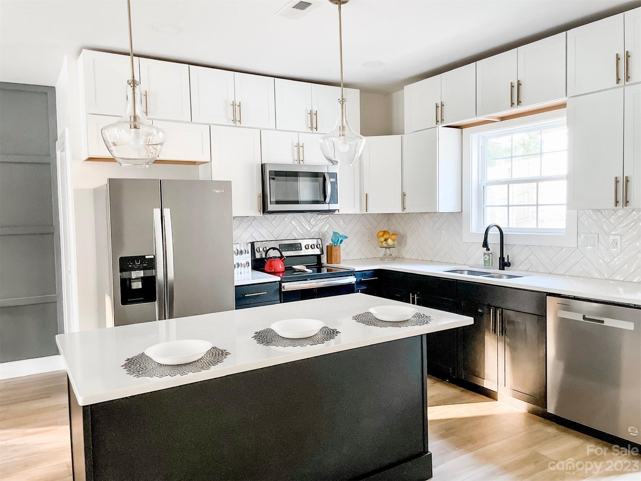 324 South Rhyne Street Gastonia, NC 28054 - Photo 3 of 11 a kitchen with stainless steel appliances a sink a stove a refrigerator a center island and a counter top space