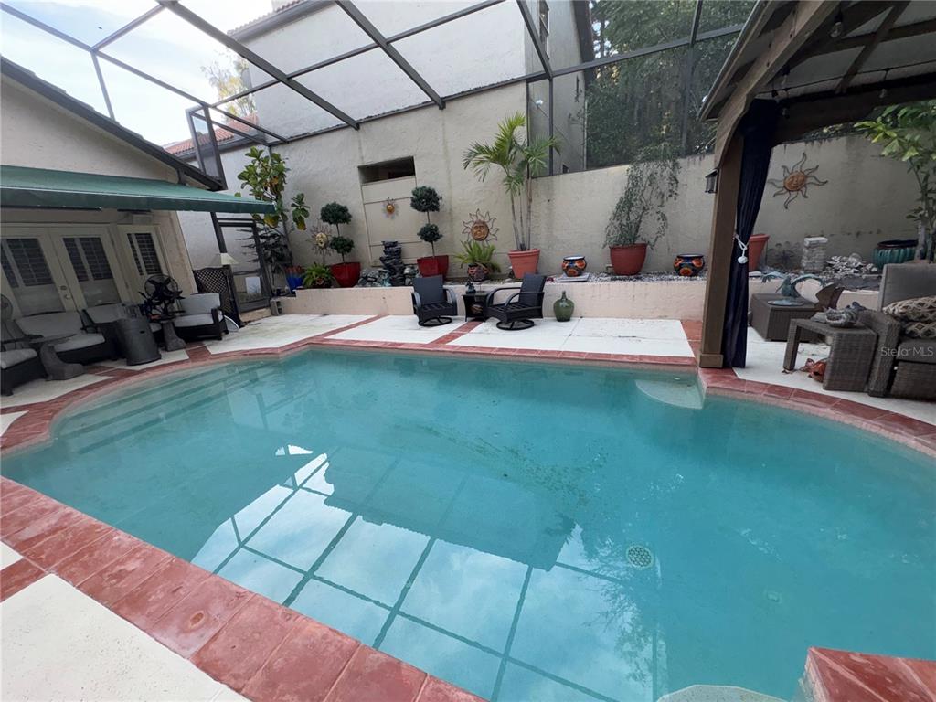 280 Springside Road Longwood, FL 32779 - Photo 11 of 29 a view of patio with table and chairs potted plants with floor to ceiling window