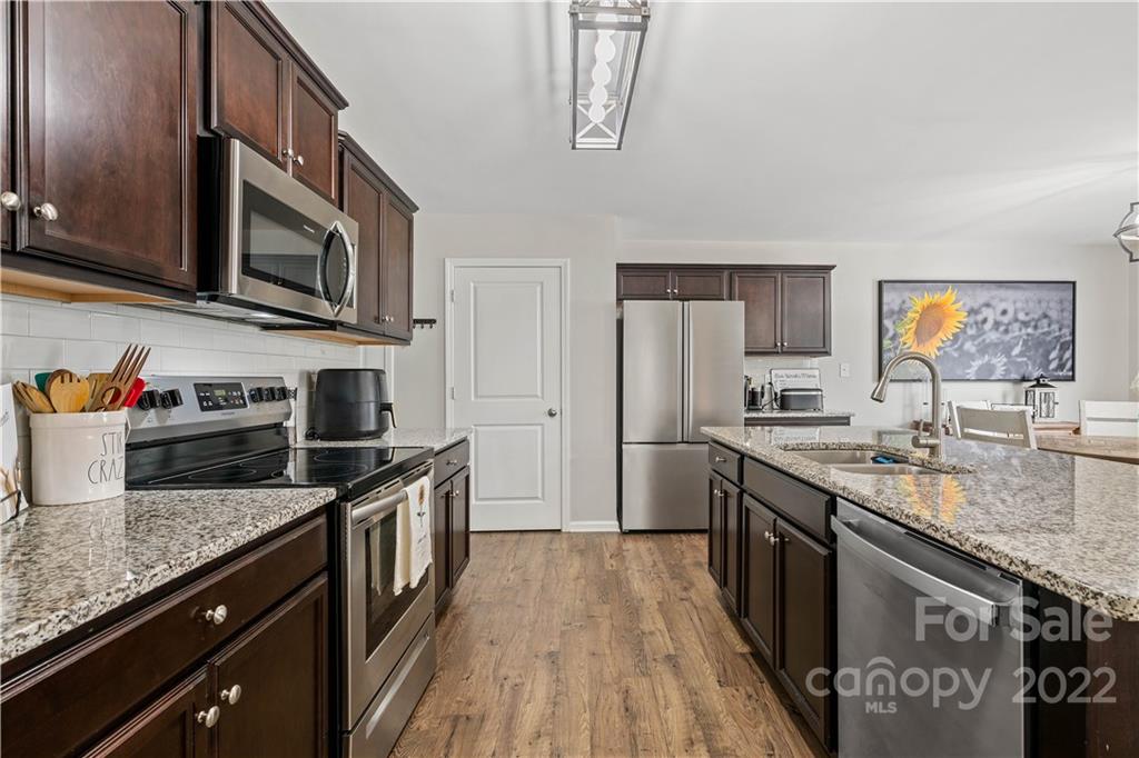 614 Shellbark Drive Concord, NC 28025 - Photo 11 of 30 a kitchen with stainless steel appliances granite countertop a stove a sink and a microwave