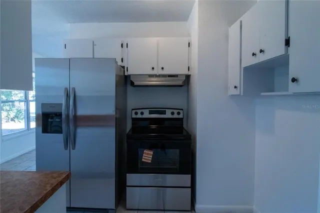 a kitchen with stainless steel appliances granite countertop a refrigerator and a stove