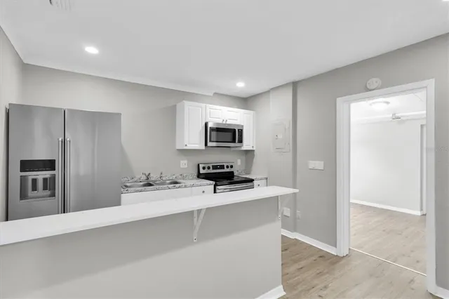 a kitchen with stainless steel appliances a refrigerator sink and stove top oven