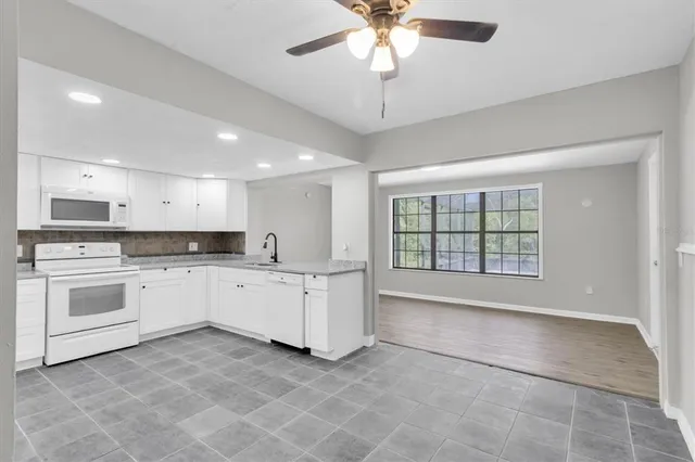 a large white kitchen with cabinets