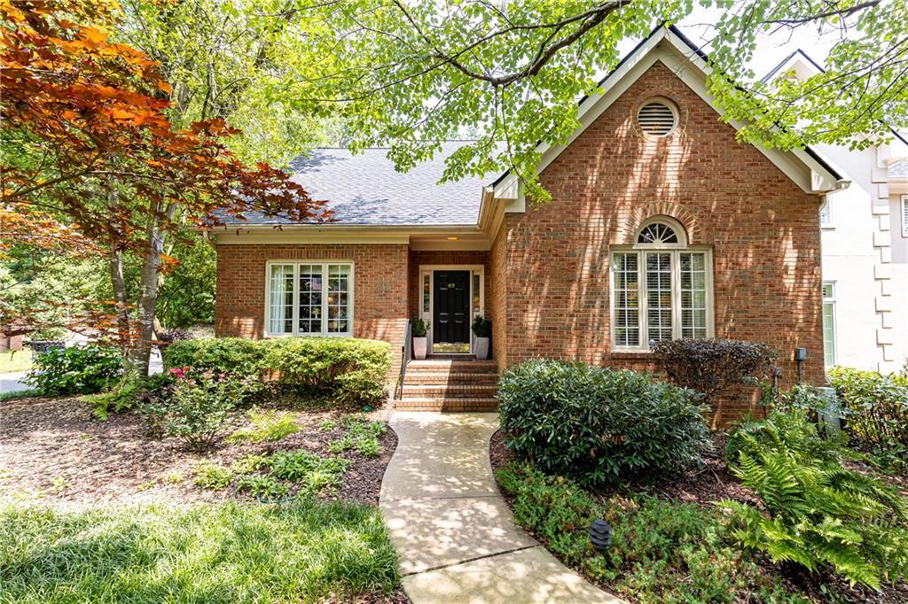 a front view of a house with a yard and potted plants