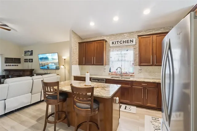 a kitchen with a sink refrigerator and cabinets